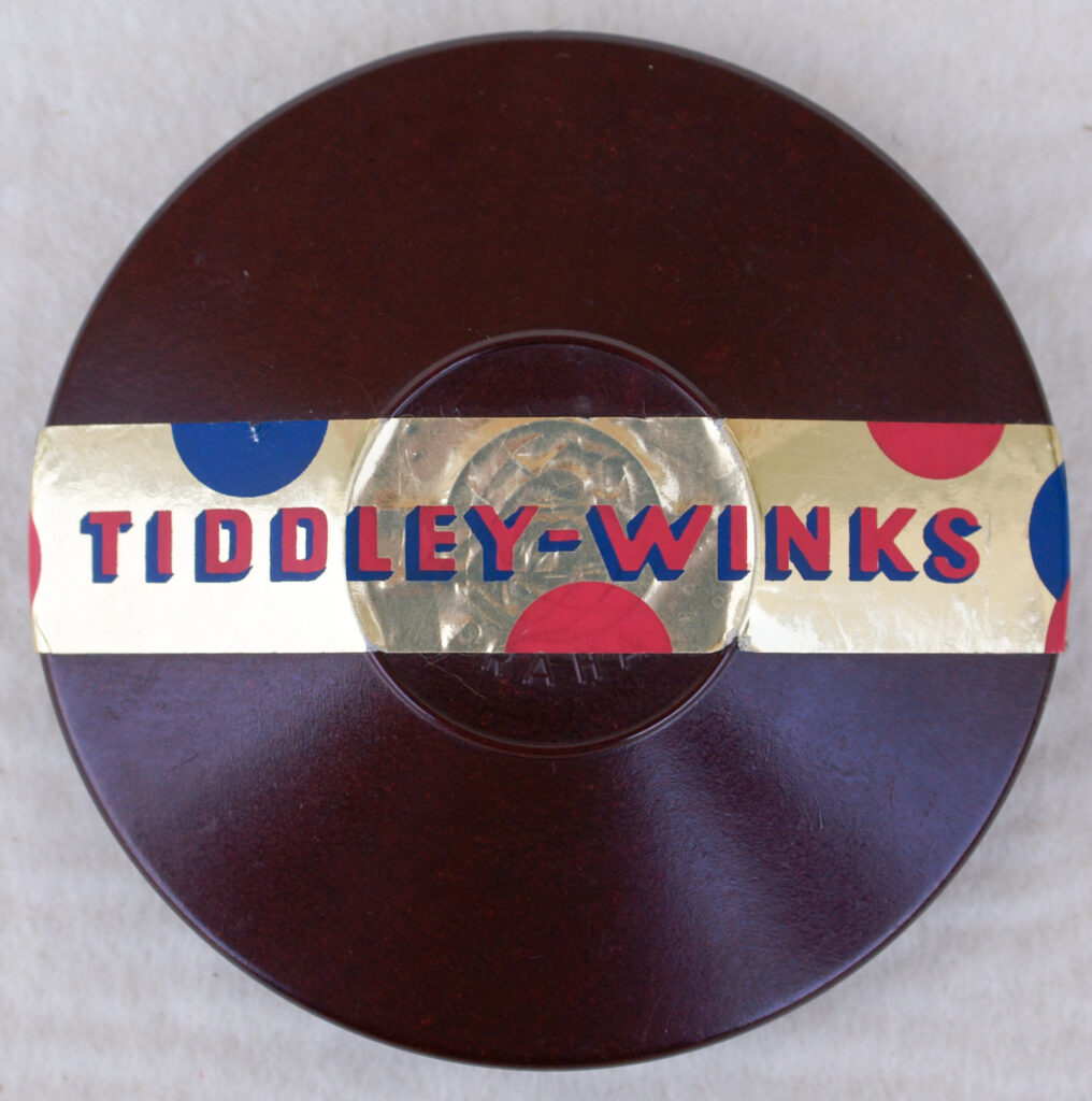 Tucker Tw ID • SMR-01c2 — AGPI ID • G-30495c2 — publisher • Směr (Praha, Czechoslovakia) — title • TIDDLEY-WINKS — notes • Dark brown round Bakelite container.